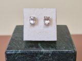 a close up of a pair of earrings sitting on top of a marble block
