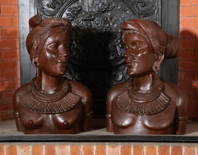 deux statues représentant une femme et un homme devant une cheminée