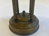 an antique brass table with a marble top and two columns