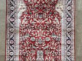 un tapis rouge et noir accroché au mur d'une pièce