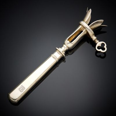un couteau en argent avec un manche en métal posé sur une surface noire
