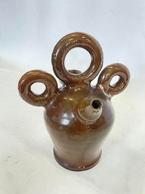 un vase marron orné d'une tête d'ours