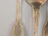 three silver spoons and two silver spoons on a white surface