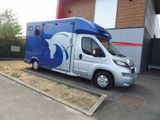 une photo d'une remorque à chevaux garée devant un bâtiment