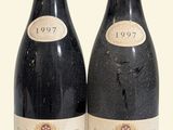 two bottles of wine sitting next to each other on a white surface