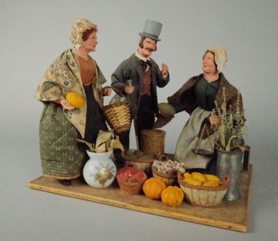 une figurine représentant un homme et une femme avec un panier de fruits