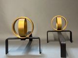two metal sculptures that are sitting on a table