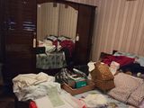a bedroom with a bed, dresser, mirror, and clothes