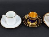 four cups and saucers are lined up on a black surface