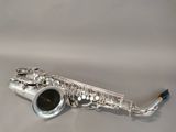 an image of a silver saxophone sitting on top of a white surface