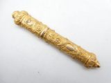 a close up of a gold pen on a white surface