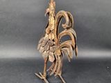 wooden sculpture of a rooster made out of leaves on a black surface
