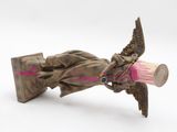 a bronze statue of a woman with a pink paint on her face