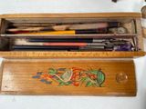 a wooden box filled with different types of pens and pencils