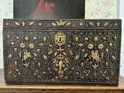 une boîte noire et dorée posée sur une table en bois