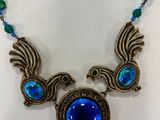 a close up of a necklace with a bird design on it
