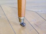 a close up of a wooden table with wheels on it