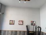 three paintings on the wall above a dining room table
