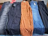 several pairs of jeans are stacked on a pallet in a warehouse