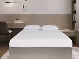 un lit blanc placé dans une chambre, à côté d'un bureau
