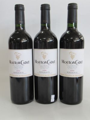trois bouteilles de vin rouge sont alignées sur une surface blanche