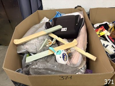 a cardboard box filled with assorted items and a suitcase