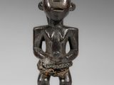 une figurine en bois représentant un homme avec une chaîne autour de la taille