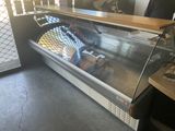 a glass display case with a variety of pastries in it