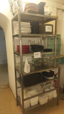 a metal shelf that has many dishes on it