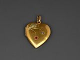 a close up of a gold heart shaped locke with a flower on it