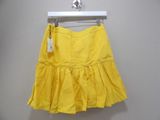 a close up of a yellow skirt hanging on a hanger