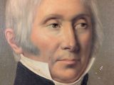 portrait of a man with white hair wearing a black coat