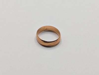 gros plan d'une bague en or sur une surface blanche