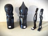 trois sculptures noires posées les unes à côté des autres sur une table