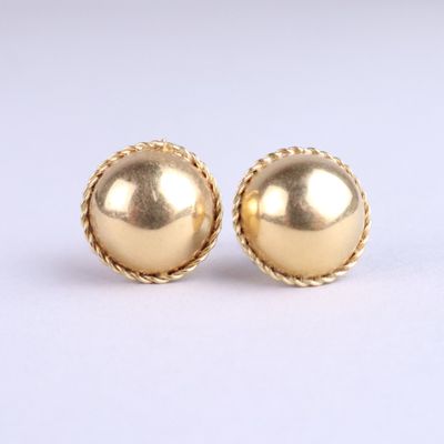 a pair of gold earrings on a white background