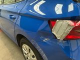 a blue car with a newspaper on the back of it
