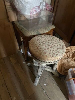 un petit tabouret avec un coussin posé dessus, dans un coin de la pièce
