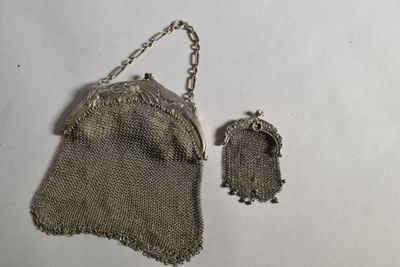 un vieux sac à main en maille argentée muni d'une chaîne et un petit sac à main argenté muni d'une chaîne