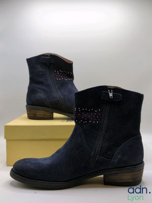 navy sued ankle boots with studs on the side and a yellow box