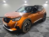 un SUV orange garé sur un sol à damier dans un garage