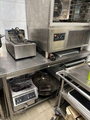 une petite cuisine avec de nombreux appareils électroménagers posés sur le plan de travail