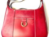 red leather purse with a gold ring on a white background
