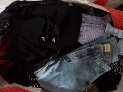 une valise remplie de vêtements posée sur un lit
