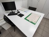un bureau sur lequel se trouvent un ordinateur, un clavier, une souris et un calendrier
