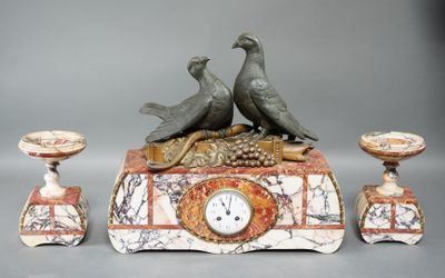two birds sitting on top of a clock with candles