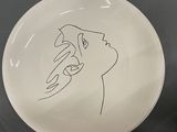 a white plate with a drawing of a person on it