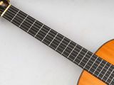an acoustic guitar sitting on top of a white surface
