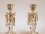 une paire de bougeoirs en verre transparent posés sur une surface blanche