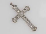 an antique silver cross with filigree decoration on a white background
