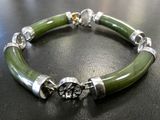 bracelet made of green jade and silver beads on a black surface
